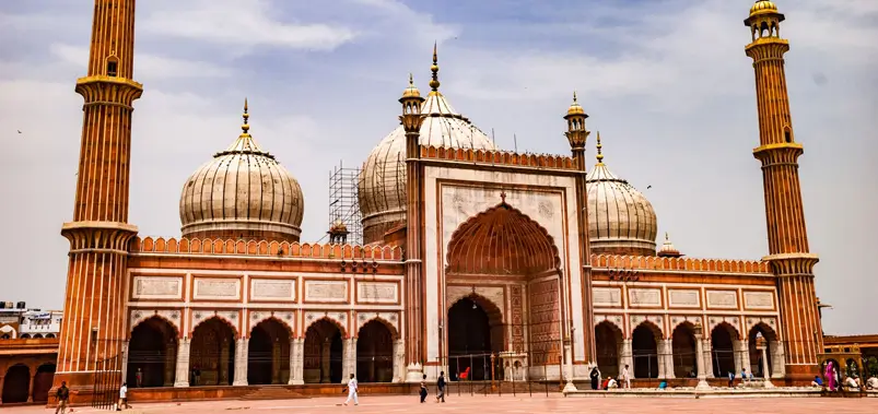 Majestic exterior view of the historic Jama Masjid mosque with tall minarets in Delhi, India.