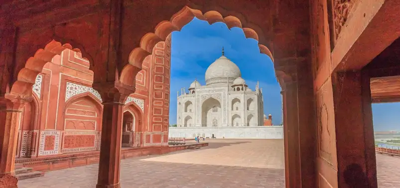 Taj Mahal viewed through a red sandstone archway in Agra, India.