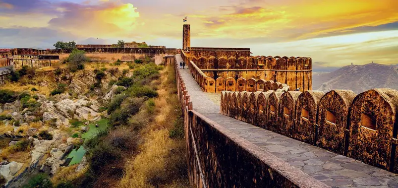 Breathtaking sunset view along the ancient stone ramparts and watchtowers of Jaigarh Fort in Jaipur, India.