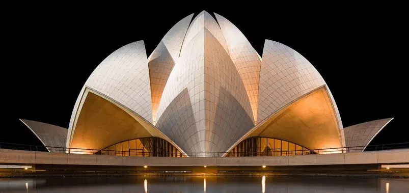 Lotus Temple illuminated at night against a dark background