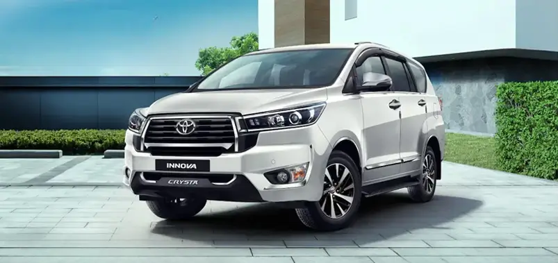 Luxury Toyota Innova Crysta SUV parked outside a modern building