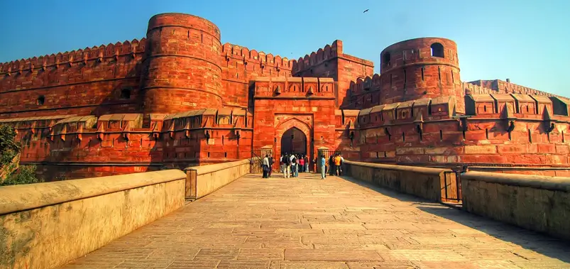 Massive red sandstone walls and gateway of Agra Fort under a clear sky
