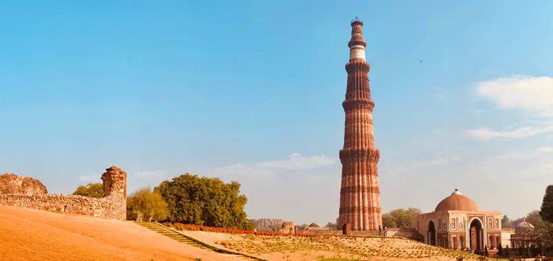 Stunning view of the historic Qutub Minar tower and surrounding ruins in Delhi, India.
